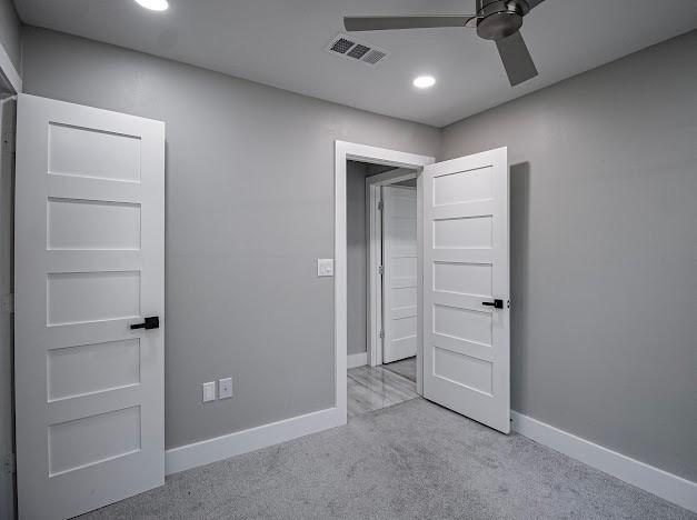 unfurnished bedroom featuring a ceiling fan, carpet, visible vents, and baseboards