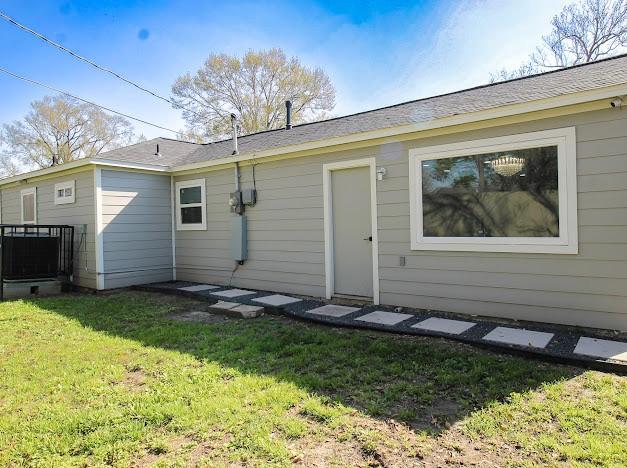 rear view of property with a lawn