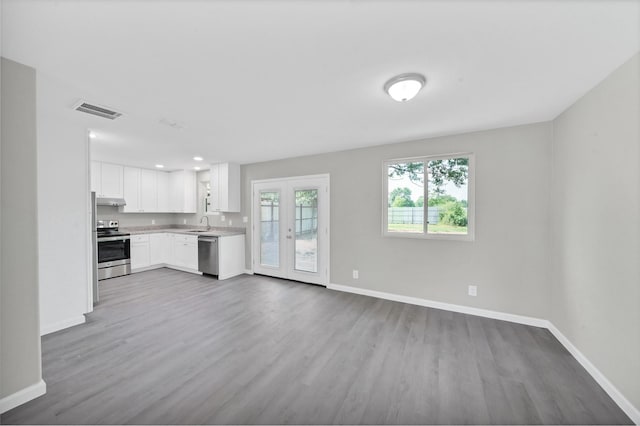 kitchen featuring visible vents, white cabinets, stainless steel appliances, light countertops, and under cabinet range hood