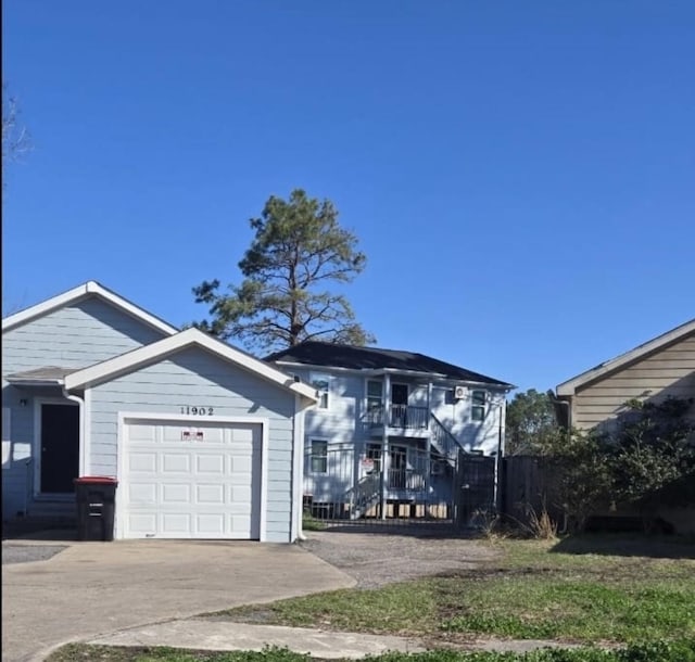 view of front of home with a garage, stairway, and fence