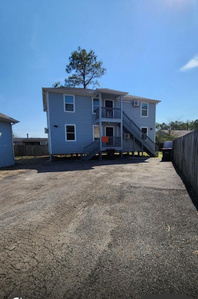 rear view of property with stairs and fence