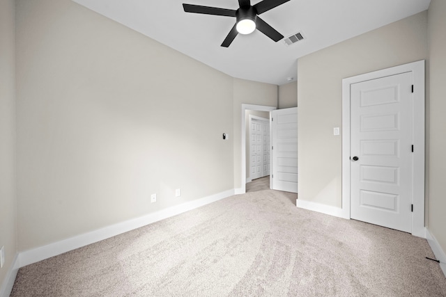 unfurnished bedroom with carpet floors, visible vents, baseboards, and ceiling fan