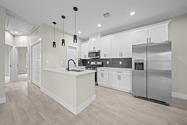 kitchen with tasteful backsplash, visible vents, white cabinets, appliances with stainless steel finishes, and a sink