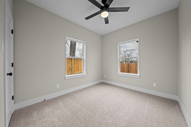 carpeted empty room with baseboards, ceiling fan, and a healthy amount of sunlight