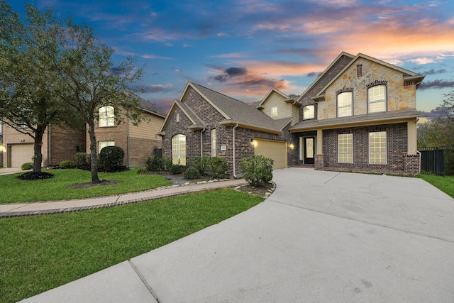 view of front of home featuring driveway, a garage, a front lawn, and brick siding