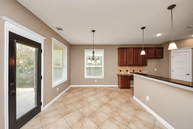 kitchen with light tile patterned floors, baseboards, visible vents, pendant lighting, and backsplash