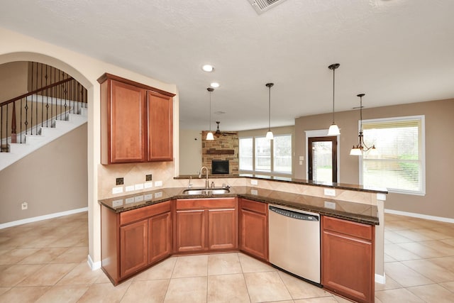 kitchen featuring decorative backsplash, brown cabinetry, dishwasher, a peninsula, and a sink