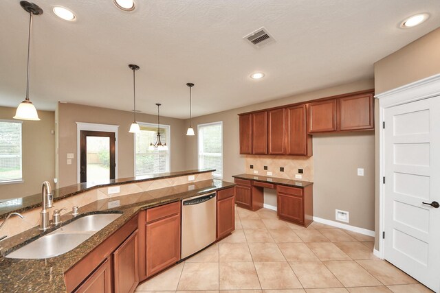 kitchen featuring a sink, brown cabinets, stainless steel dishwasher, and hanging light fixtures