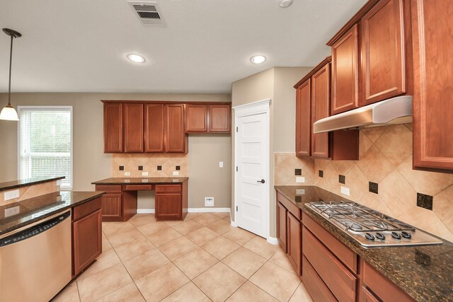 kitchen featuring brown cabinets, stainless steel appliances, visible vents, dark stone counters, and under cabinet range hood