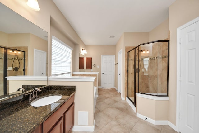 bathroom featuring visible vents, a shower stall, vanity, tile patterned flooring, and baseboards