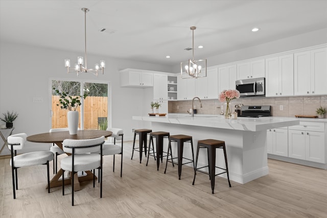 kitchen with stainless steel appliances, a chandelier, visible vents, and a sink