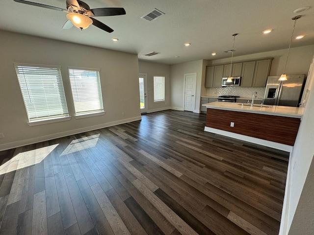 kitchen with gray cabinetry, visible vents, open floor plan, light countertops, and appliances with stainless steel finishes