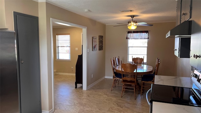 dining space with baseboards, visible vents, a ceiling fan, crown molding, and a textured ceiling