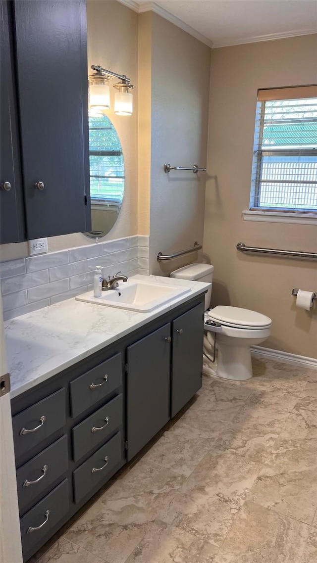 bathroom featuring ornamental molding, vanity, and toilet