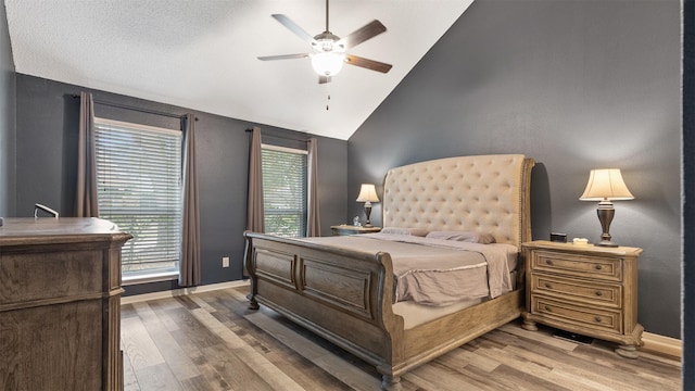 bedroom featuring lofted ceiling, baseboards, and wood finished floors