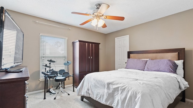 bedroom featuring light carpet, ceiling fan, a textured ceiling, and baseboards