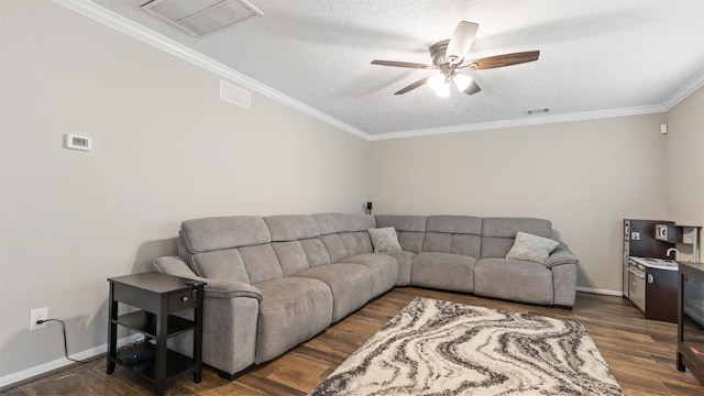 living room with baseboards, visible vents, dark wood finished floors, a ceiling fan, and ornamental molding