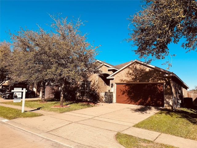 view of front of property featuring concrete driveway, an attached garage, fence, a front lawn, and brick siding