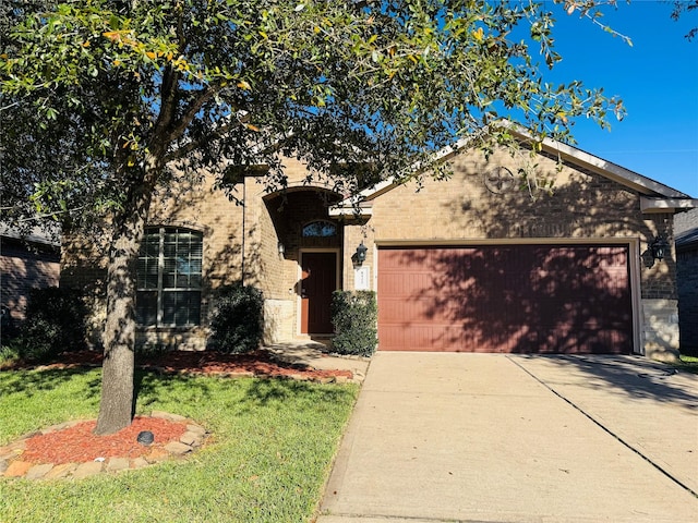 view of front of home featuring a garage, concrete driveway, brick siding, and a front yard