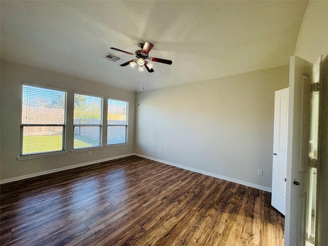 empty room with dark wood-style flooring and baseboards