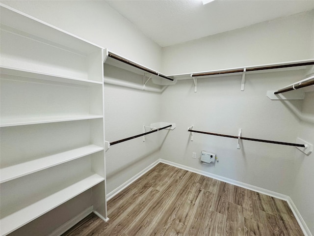 walk in closet with wood finished floors