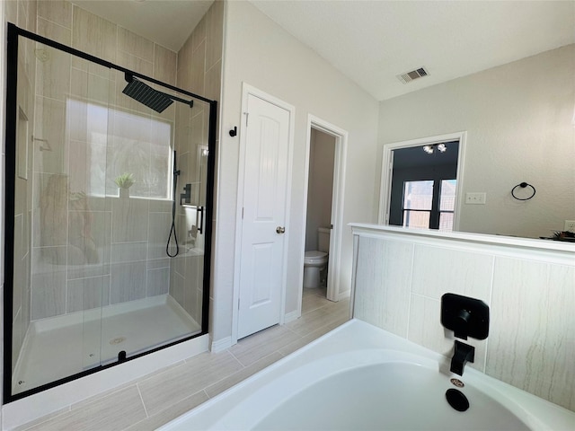 full bath with toilet, a stall shower, and visible vents