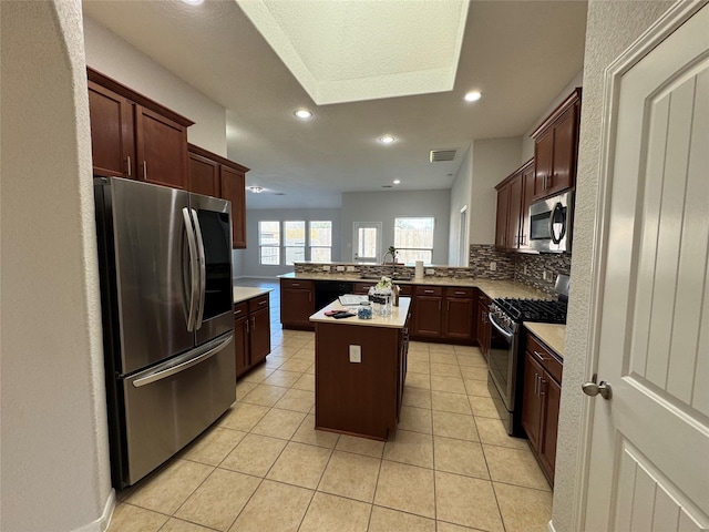 kitchen with light tile patterned floors, visible vents, decorative backsplash, appliances with stainless steel finishes, and a peninsula