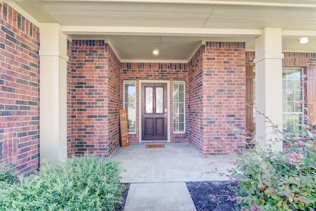 entrance to property featuring brick siding