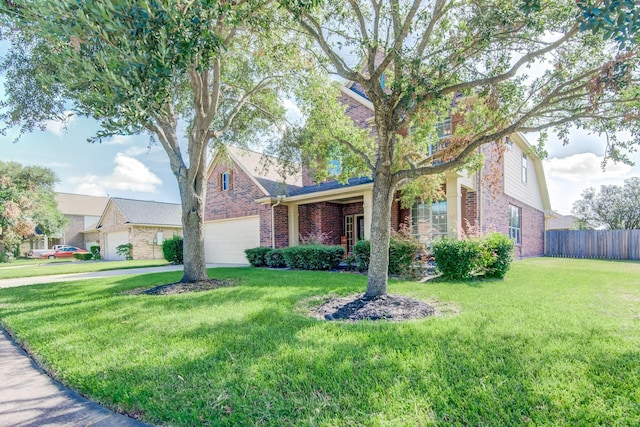 view of front of house featuring a front yard, brick siding, fence, and an attached garage