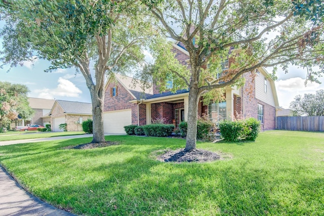 view of front facade with a garage, a front yard, fence, and brick siding