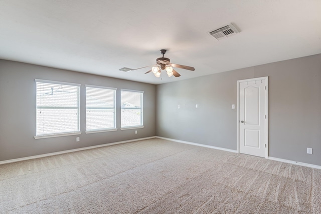 unfurnished room featuring ceiling fan, carpet flooring, visible vents, and baseboards