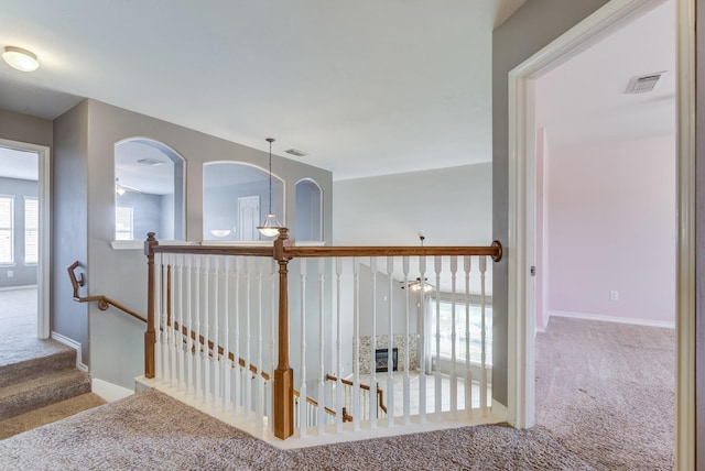 hall featuring carpet, visible vents, and baseboards