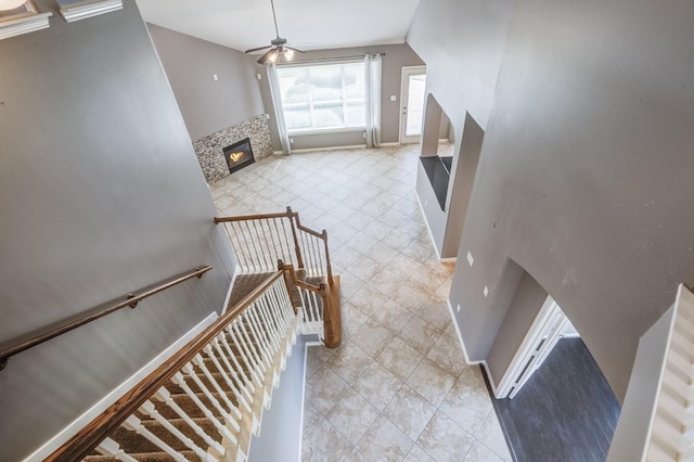 stairway featuring tile patterned floors, a fireplace, baseboards, and ceiling fan