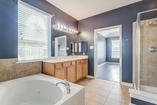 bathroom with a tub with jets, tile patterned flooring, and a healthy amount of sunlight