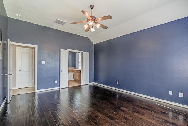 unfurnished bedroom featuring visible vents, vaulted ceiling, baseboards, and wood finished floors