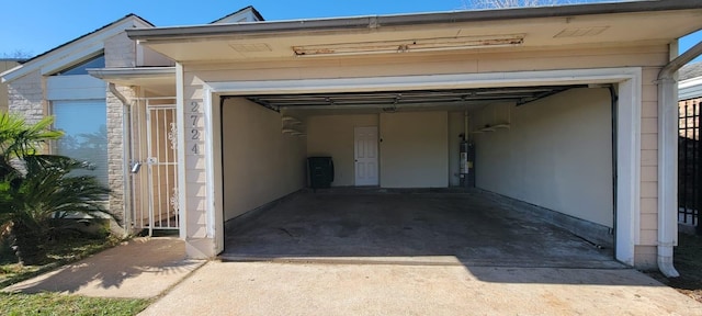 garage with water heater and driveway