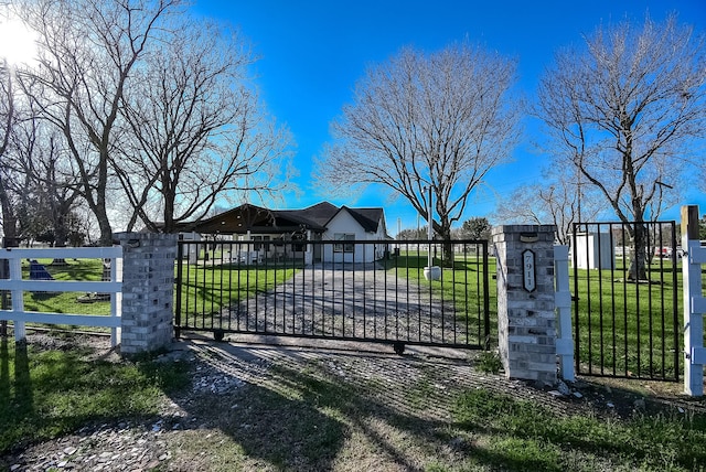 view of gate featuring a lawn and fence