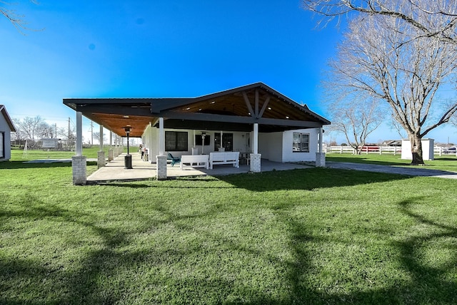 back of property with a patio, a yard, and fence