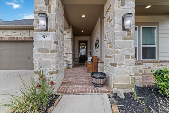 doorway to property featuring a garage and stone siding