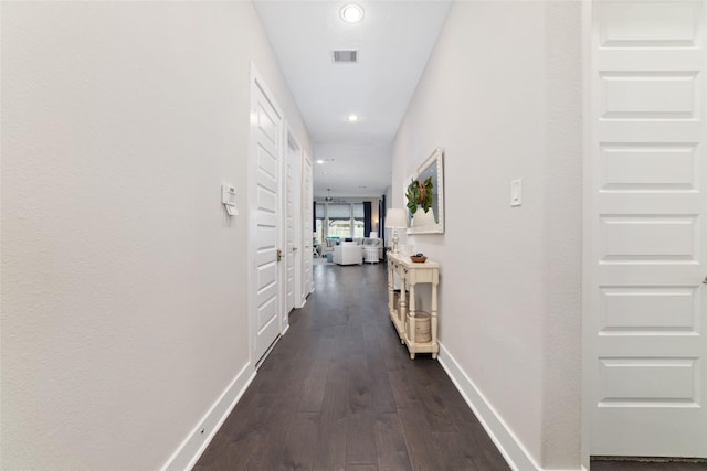 corridor featuring baseboards, visible vents, dark wood finished floors, and recessed lighting