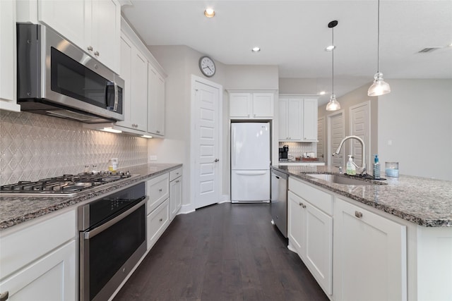 kitchen featuring appliances with stainless steel finishes, white cabinets, and a sink