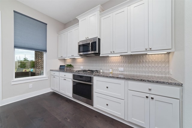 kitchen featuring appliances with stainless steel finishes, stone counters, white cabinets, and decorative backsplash