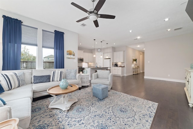 living room with dark wood-style floors, baseboards, visible vents, and recessed lighting