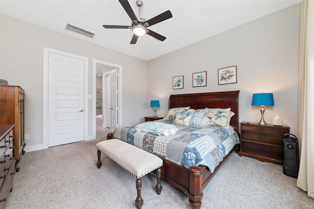 carpeted bedroom with ensuite bath, ceiling fan, and visible vents