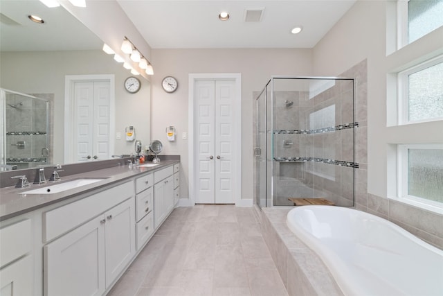 full bathroom featuring a closet, a sink, a shower stall, and double vanity