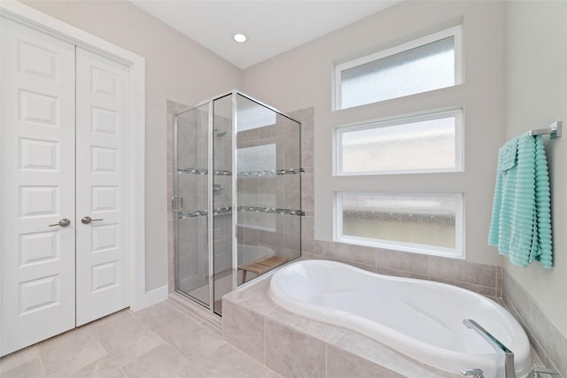 bathroom with a garden tub, a shower stall, and tile patterned floors