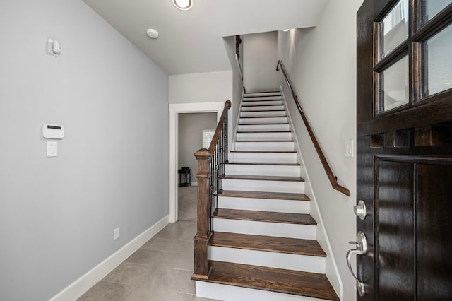 stairs with tile patterned floors and baseboards