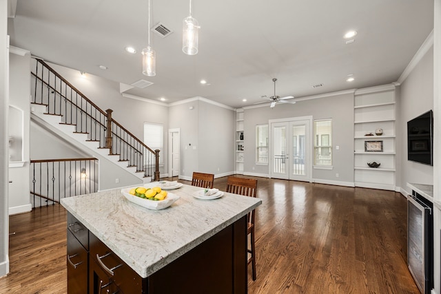 kitchen with built in features, dark wood-style flooring, crown molding, and baseboards