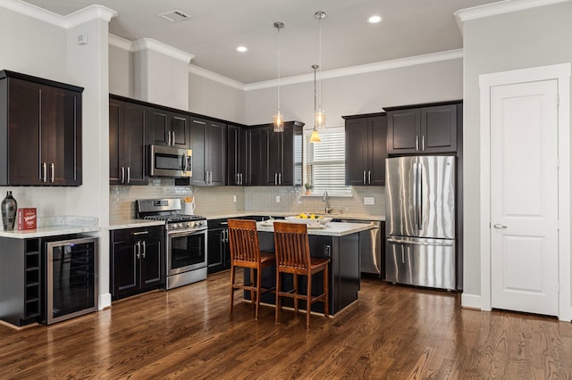 kitchen featuring beverage cooler, stainless steel appliances, dark wood-style flooring, visible vents, and a center island