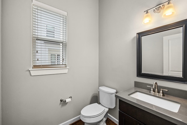 bathroom featuring vanity, toilet, and baseboards